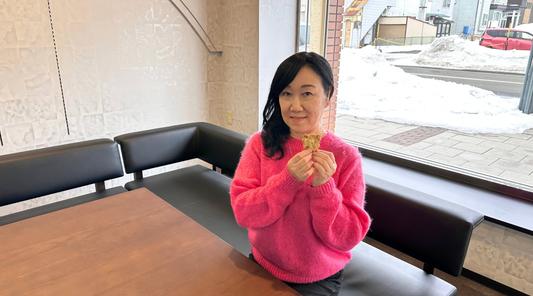 FOOD LABO FORTUNAの店内で、米粉のお菓子を手にするTSUMA